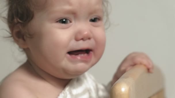 Un niño pequeño juega en la cuna . — Vídeo de stock
