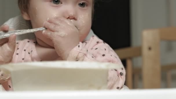 En liten flicka som äter gröt.. — Stockvideo