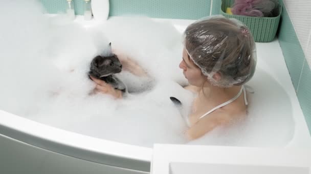 En kvinna badar en katt i badrummet. — Stockvideo