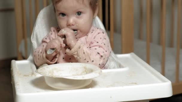 Menina pequena comendo mingau de cereal . — Vídeo de Stock