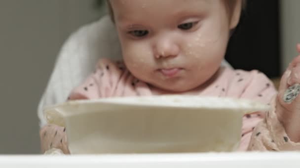 Menina pequena comendo mingau de cereal . — Vídeo de Stock