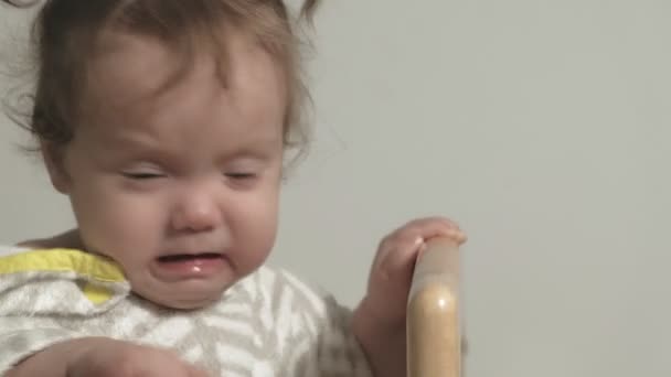 Uma criança pequena brinca no berço . — Vídeo de Stock