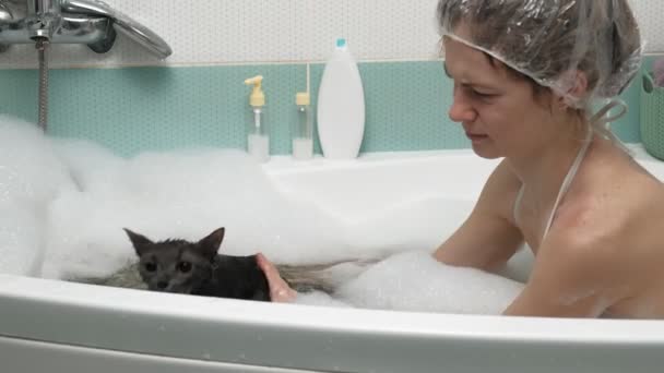 Egy nő megfürdik egy macskát a fürdőszobában.. — Stock videók