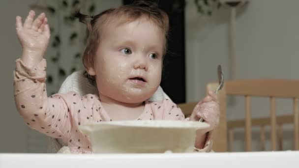 Маленька дівчинка їсть кашу . — стокове відео