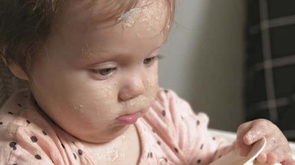 Malé batole dívka jíst ovesnou kaši. — Stock video