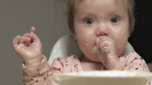 Menina pequena comendo mingau de cereal . — Vídeo de Stock