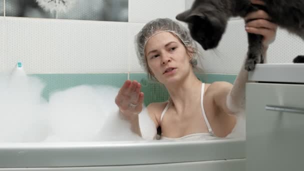 Una mujer baña a un gato en el baño . — Vídeos de Stock