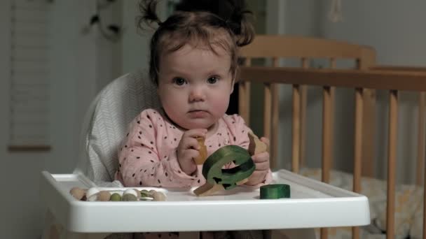 Petite fille joue avec un jouet en bois. Le développement de la motricité fine — Video