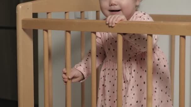 Το μικρό παιδί είναι ένα χαρούμενο κορίτσι σε μια καρέκλα μωρού. — Αρχείο Βίντεο