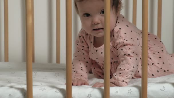 Маленький ребенок играет в кроватке . — стоковое видео