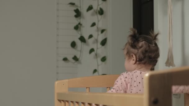 Pequeño niño es una niña alegre en una silla de bebé . — Vídeo de stock