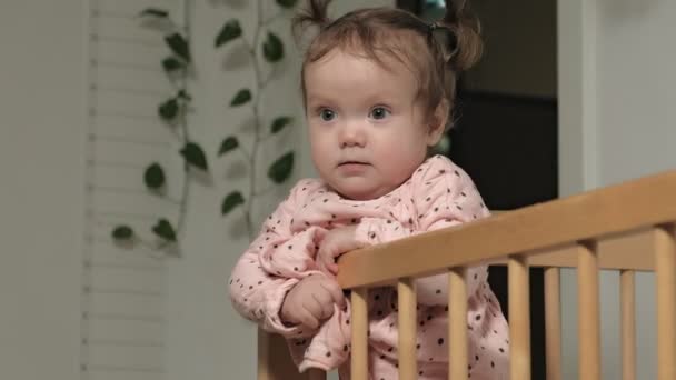 Little child is a cheerful girl in a baby chair. — Stock Video