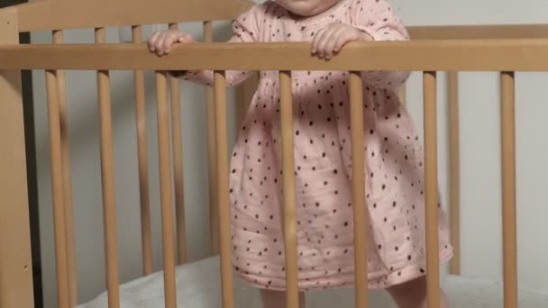 Pequeño niño es una niña alegre en una silla de bebé . — Vídeos de Stock