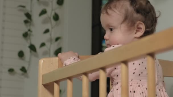 Petit enfant est une fille joyeuse dans une chaise de bébé . — Video