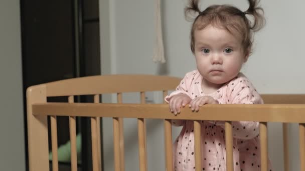 Little child is a cheerful girl in a baby chair. — Stock Video