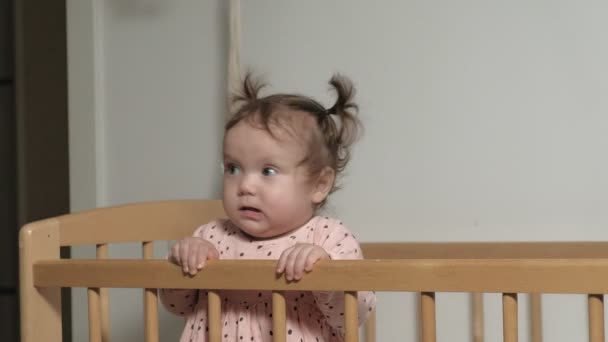 Το μικρό παιδί είναι ένα χαρούμενο κορίτσι σε μια καρέκλα μωρού. — Αρχείο Βίντεο