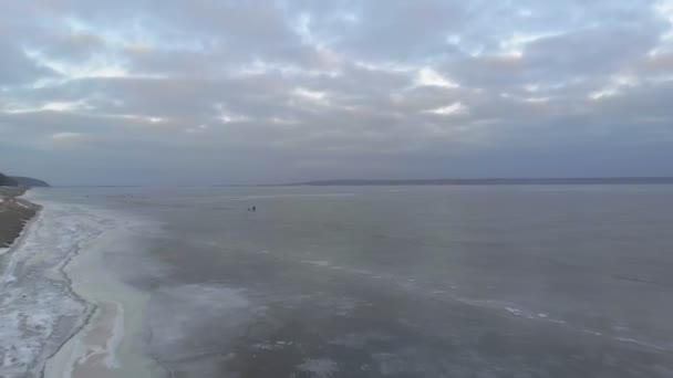 Die Menschen gehen auf einem zugefrorenen Fluss. Luftbild — Stockvideo