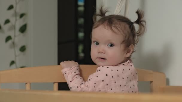 Little child is a cheerful girl in a baby chair. — Stock Video