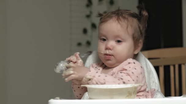 Menina pequena comendo mingau de cereal . — Vídeo de Stock