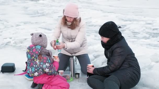 People walk on a frozen river — Stock Video