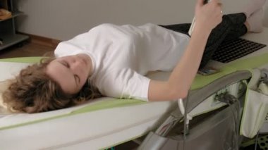 Bir kadın masaj elektronik yatağında yatıyor..