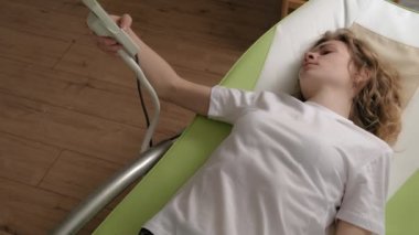 Bir kadın masaj elektronik yatağında yatıyor..