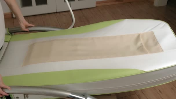Uma mulher está em uma cama eletrônica de massagem . — Vídeo de Stock