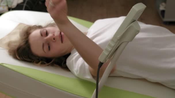 Una mujer se acuesta en una cama electrónica de masaje . — Vídeos de Stock
