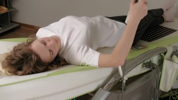 Жінка лежить на масажному електронному ліжку . — стокове відео
