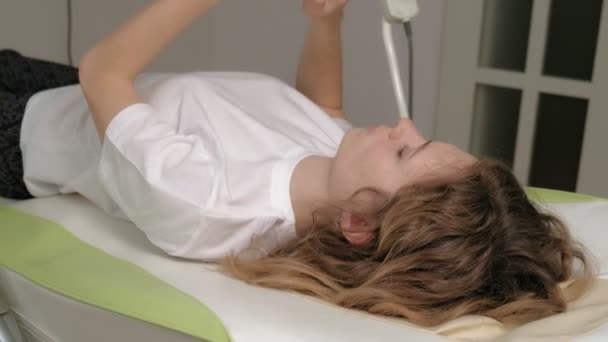 Una donna si trova su un letto elettronico massaggio . — Video Stock