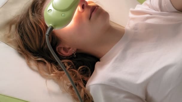 En kvinna ligger på en massagesäng med jade rollers. — Stockvideo
