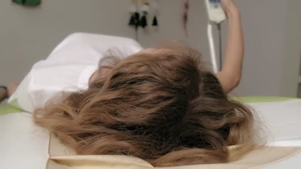 Una mujer se acuesta en una cama electrónica de masaje . — Vídeo de stock