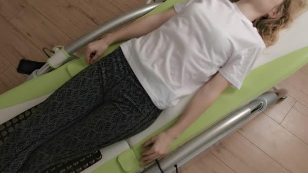 Una donna si trova su un letto elettronico massaggio . — Video Stock