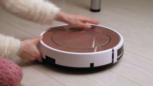 A woman uses a robot vacuum cleaner. Modern technologies — Stock Video