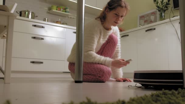 Genç bir kadın robotu süpürüyor.. — Stok video
