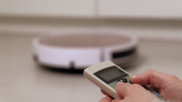 A young woman is vacuuming a robo — Stock Video