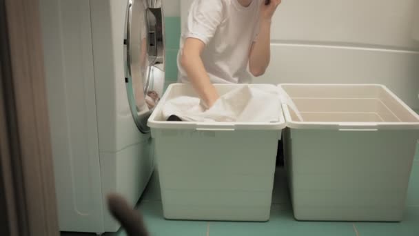 Eine Frau sortiert Wäsche vor dem Waschen. — Stockvideo