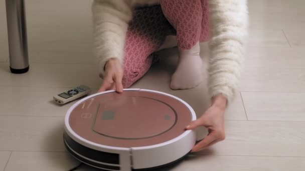 Μια γυναίκα χρησιμοποιεί μια ηλεκτρική σκούπα ρομπότ. Νέες τεχνολογίες — Αρχείο Βίντεο