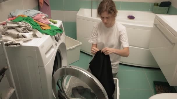 Žena třídí prádlo před praním.