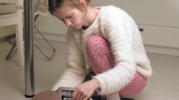 Une femme utilise un robot aspirateur. Technologies modernes — Video