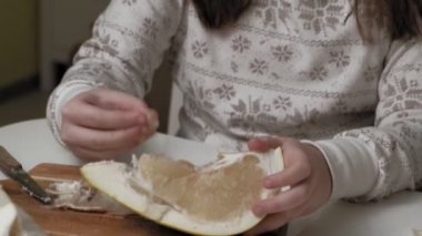 İki kız kardeş pomelo yiyor.