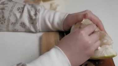 İki kız kardeş pomelo yiyor.