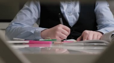 Okul üniformalı genç kız ev ödevi yapıyor.