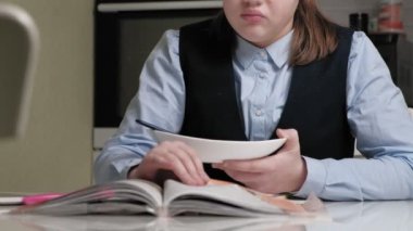 Okul üniformalı genç kız ev ödevi yapıyor.