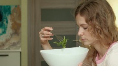 Genç kadın yeşil salata yiyor..