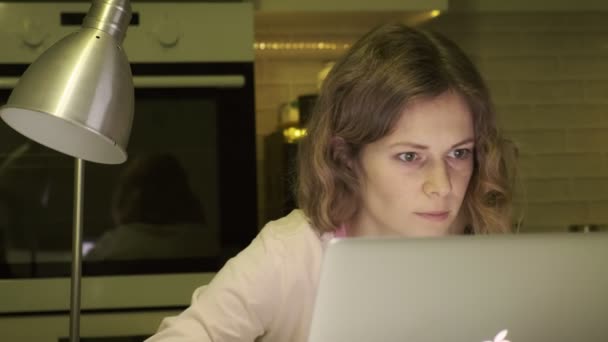 Una joven trabaja en una computadora en casa. . — Vídeo de stock