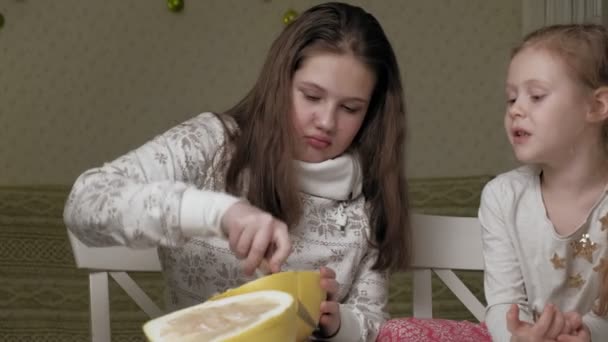 Two sisters eating pomelo fruit — Stock Video