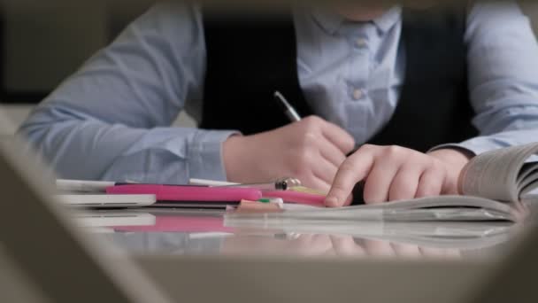 Девочка-подросток в школьной форме делает домашнее задание — стоковое видео