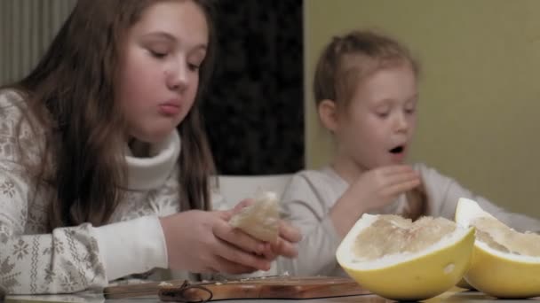 Two sisters eating pomelo fruit — Stock Video