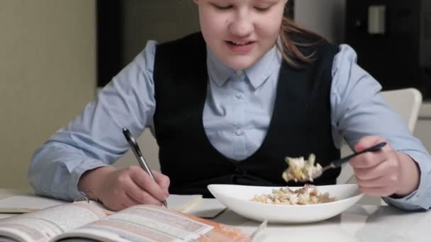 Девочка-подросток в школьной форме делает домашнее задание — стоковое видео